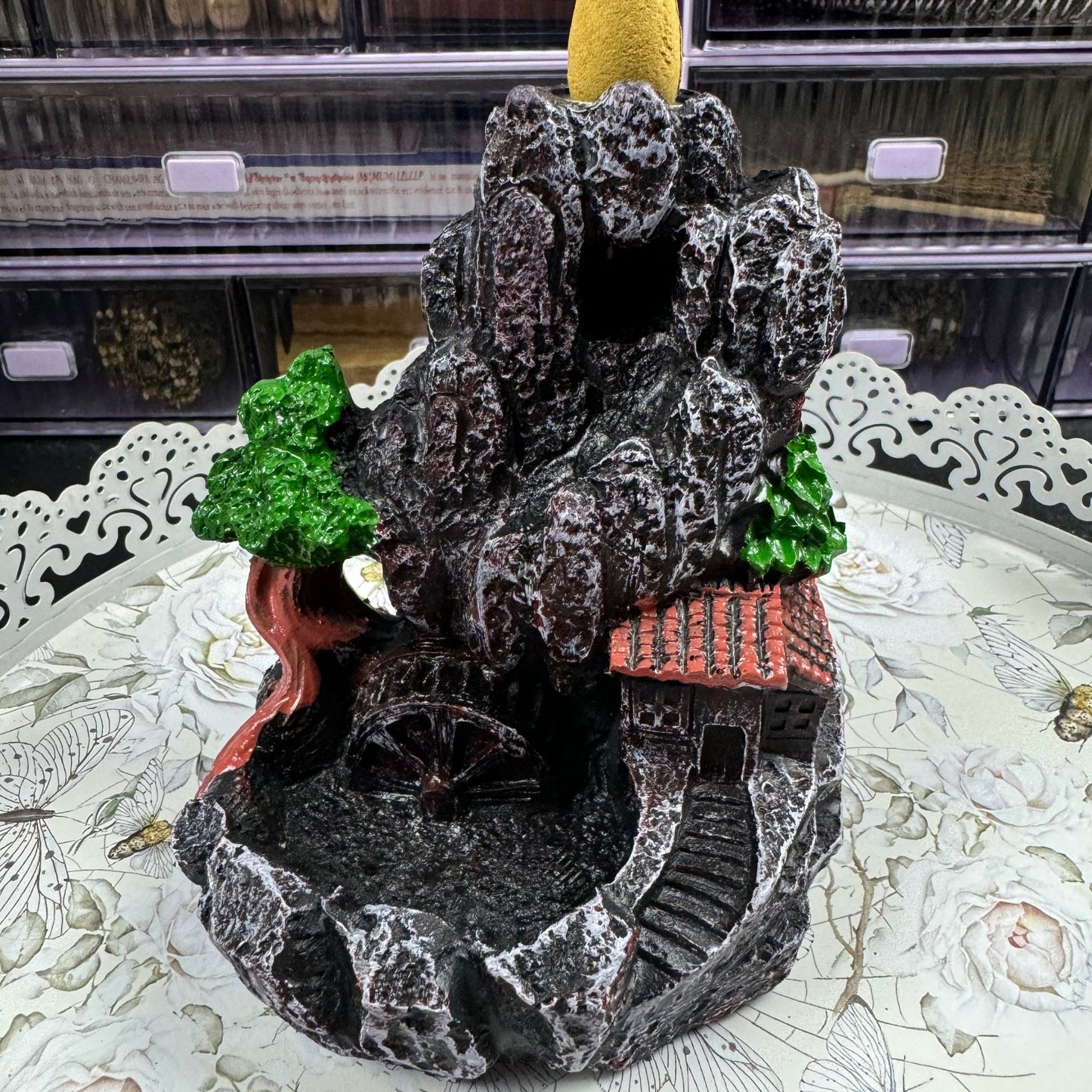 Decorative mountain incense burner with trees and a house on a table