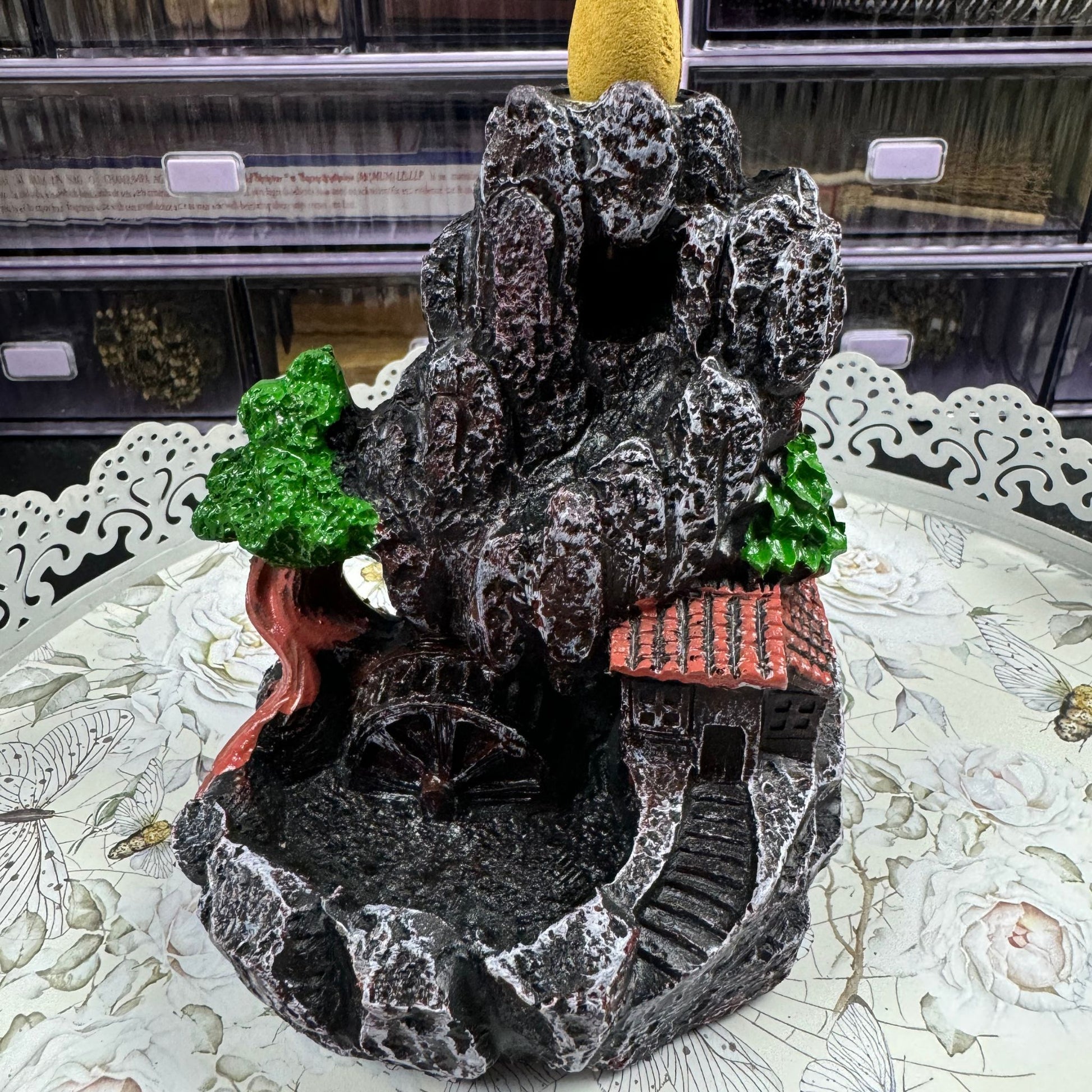 Decorative mountain incense burner with trees and a house on a table